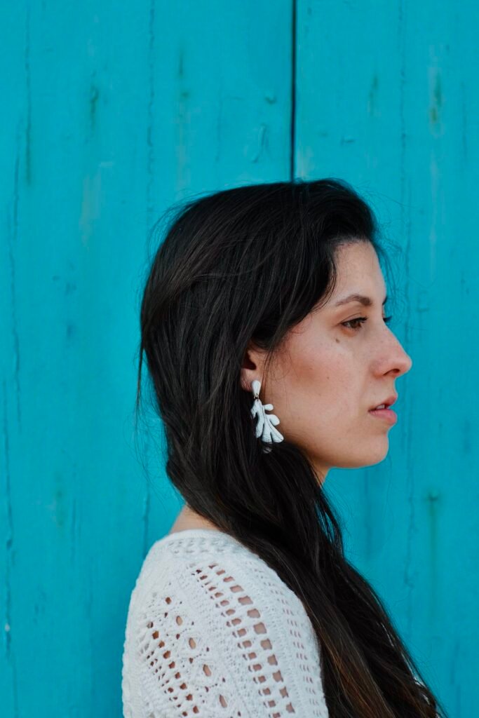 Model at tipical mediterranean blue painted door with Handmade Mediterranean earrings — Hibiscus Amarillo Costa Brava photoshoot

