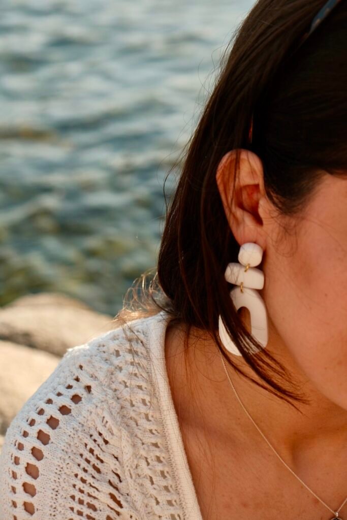 Handcrafted Hibiscus Amarillo earrings worn by a model during early summer sunset by the Mediterranean in Costa Brava.