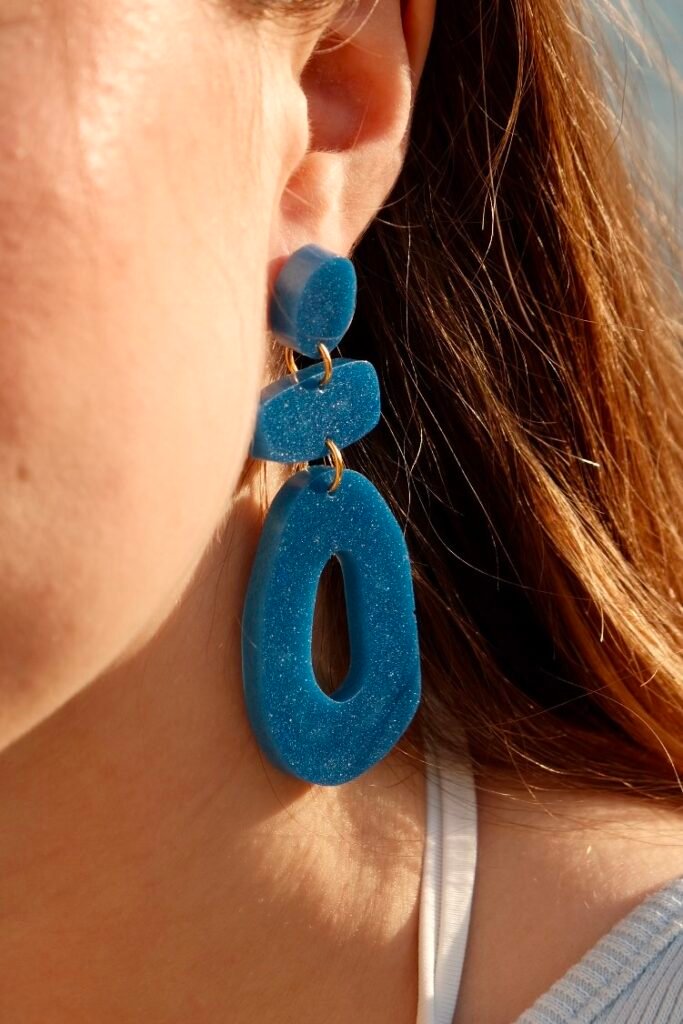 Handcrafted Hibiscus Amarillo earrings worn by a model during early summer sunset by the Mediterranean in Costa Brava.