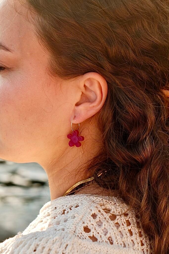 Handcrafted Hibiscus Amarillo earrings worn by a model during early summer sunset by the Mediterranean in Costa Brava.